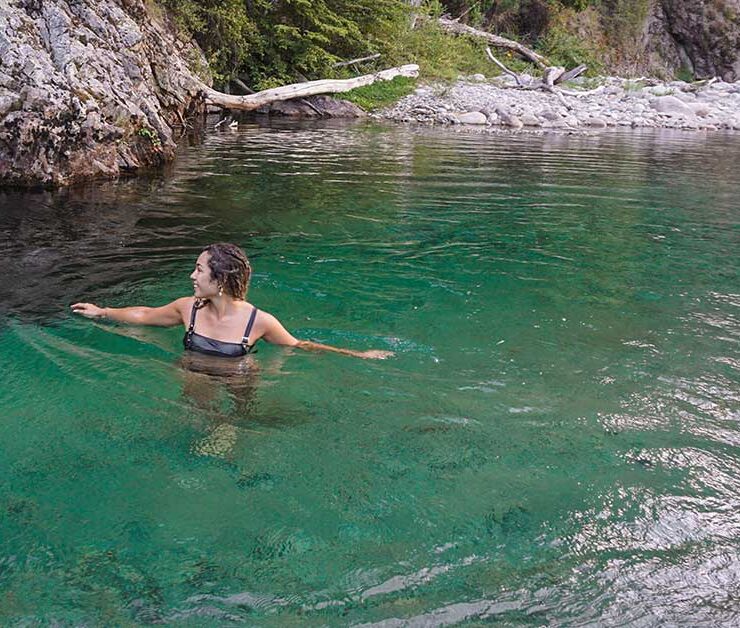 woman cooling off in a beautiful blue swimming hole