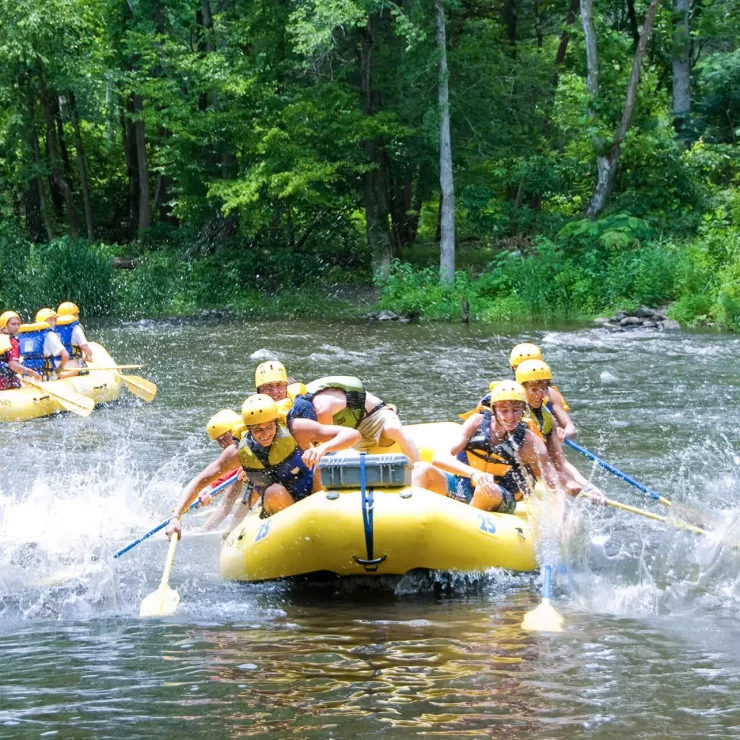 groups of people white water rafting in two inflatable boats